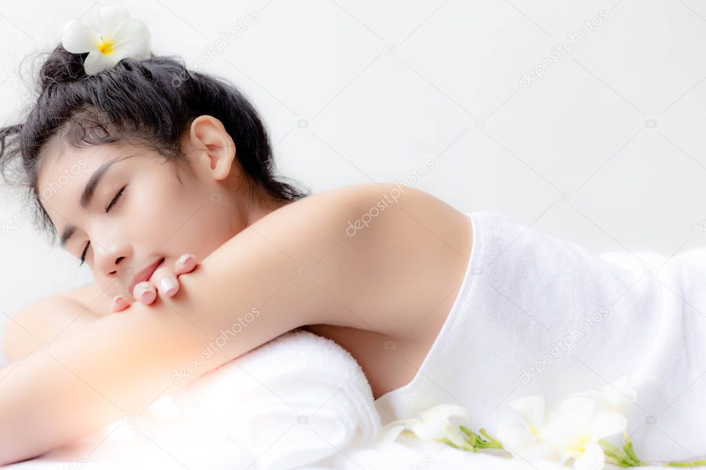 Charming beautiful Asian woman is lying on bed at spa shop. Gorgeous asia girl is customer and waiting for massager. Attractive young woman feels relaxed and happy. She has good health. copy space