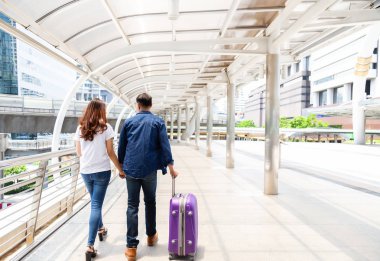 Sevimli seyahat etmek yakışıklı ve güzel kadın tatil olsun. Güzel çift el ve sokakta City birlikte yürüyüş ve turistik yere gidiş tutun. Balayı var. Adam sürükle bavul.