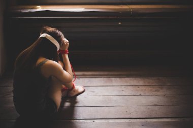 Kaçırmak veya kaçırmak ağlıyor ve hissediyor umutsuz, yalnızlık bir kızdır. Güzel kadın ticareti, kaçırmak veya kaçırmak. Zavallı kadın kravat ip, kollar, bacaklar ve gözü kapalı. Ahşap zemin üzerinde oturmak. kopya alanı