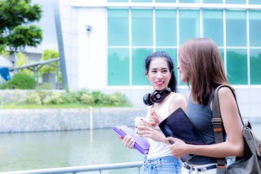 Güzel Asyalı yabancı üniversite öğrencisi kız arkadaşıyla yürüyor. Onlar sınıfa gidiyor. Asya öğrenci kadınlar hakkında komik konuşuyor ya da üniversitede yürürken şaka hikayeleri