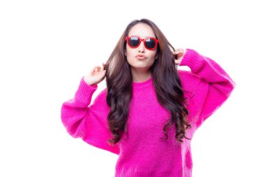 Kış sezonunda pembe kazak giyen güzel genç kadın aşk çekici. Çekici güzel kadın alır neşeli ve mutluluk. Güzel kadın giyim güneş gözlüğü ve öpüşme. izole beyaz arka plan