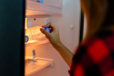 Güzel kadın susamış maden suyu veya soğuk su gece zaman alır ve o buzdolabı şişe su kullanır. Güzel kız istiyorum soğuk su sıcak hava nedeniyle yaz sezonunda içme.