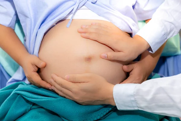 英俊的医生正在检查胎儿的位置通过触摸孕妇腹部在医院 美丽的母亲或怀孕的妇女怀孕九月 几乎分娩 她呆在医院的房间里 — 图库照片