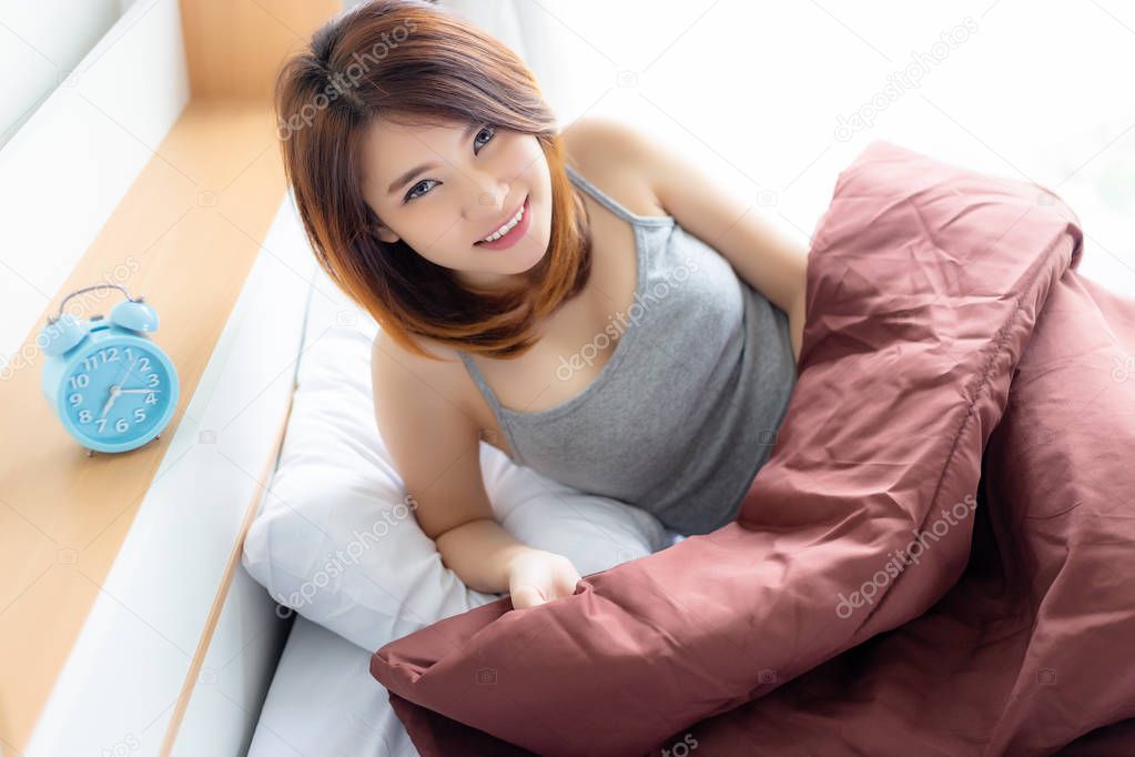 Attractive beautiful woman is waking up in the morning with feeling fresh because pretty girl sleep well all night. Gorgeous woman looks vivacious and happy with smiley face. She gets good health