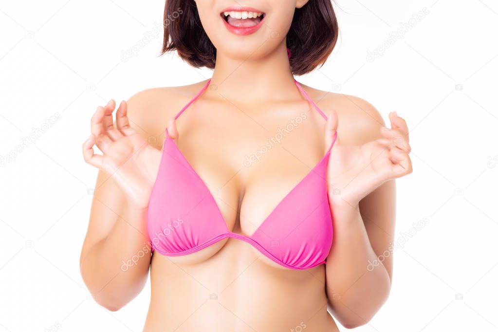 Charming beautiful young woman showing sexy breasts. Attractive beautiful girl gets satisfied and happy new boobs after gets surgery of breasts by putting silicone. isolated on white background