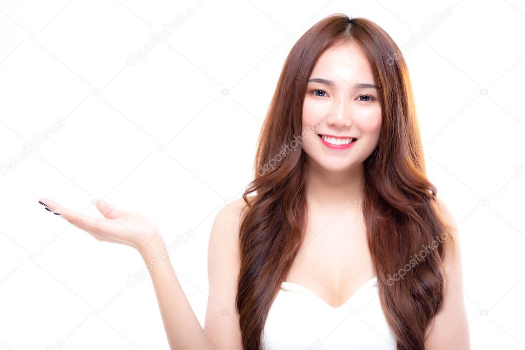 Portrait of charming beautiful woman smiling and showing empty hand while looking at camera isolated on white background, close-up