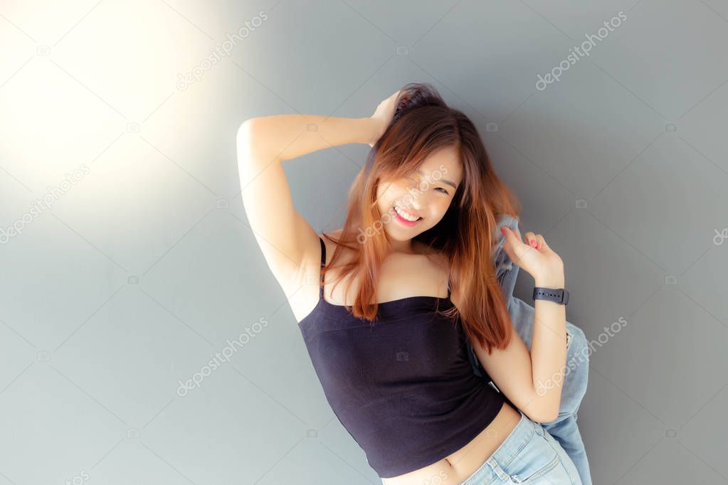 Portrait cheerful woman. Attractive beautiful woman gets happiness with smile face. Charming beautiful young lady wears jeans, camisole and holding denim denim jacket. Cool girl has nice skin and body