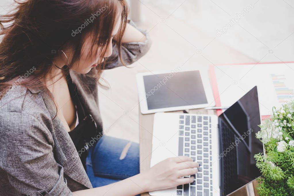 Attractive beautiful businesswoman is working on laptop computer at outdoor. Beautiful woman get confused about some information or some order from customer or employer. Sexy woman gets headache