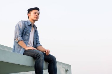 Portre yakışıklı adam: adam büyüleyici manzarasına arıyor, bu onu mutlu ediyor. Çekici erkek rahat ve kararlı hissediyorum. Cool adam giyim denim ceket, yelek. kot pantolon. Çekici görünüyor. kopya alanı