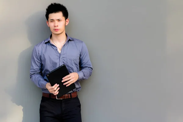 Handsome businessman holding tablet. Attractive handsome guy look smart and thinking something. Charming handsome young man is expert of  retail investors and playing stock markets