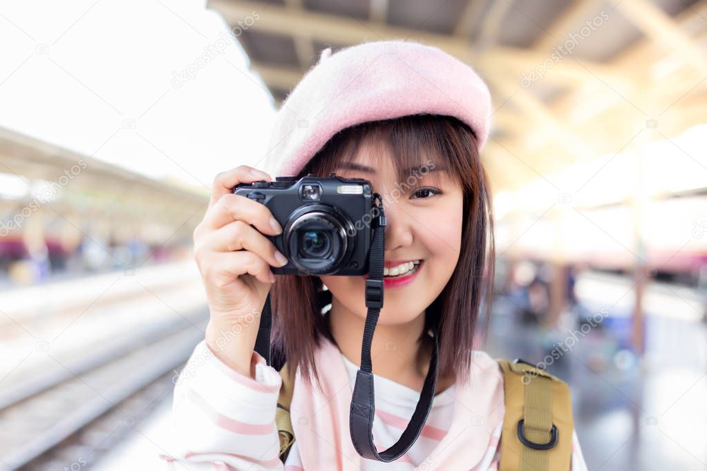 Portrait beautiful traveller woman take photo. Attractive beautiful tourist woman use camera for taking photos some beautiful place. Charming beautiful woman is traveling by alone. She feel happiness