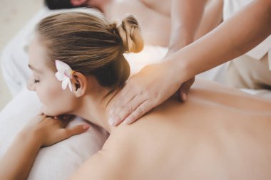 Lüks tatil veya otelde spa salonunda masör masaj müşteri arka boyun. Güzel müşteri kadın rahatlatıcı hissediyorum, rahat, tatmin. Çekici güzel kadın spa salonunda yatağa uzandı