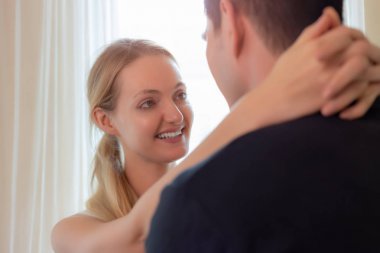 Sevimli çift ya da aşıklar birbirlerini kucaklıyorlar. Yakışıklı genç asyalı adam ve birbirlerine aşık güzel genç beyaz kadın. Çekici güzel genç kadın sevgi ile yakışıklı erkek arkadaşı bakmak