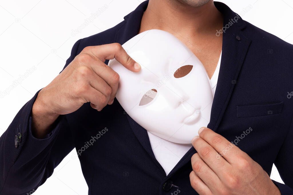 Two faced of Businessman hide white mask and put artificial mask to pocket suit. White collar worker is dishonest guy. Cheating man betray business partner, dishonest hiding in mask. Young man is spy