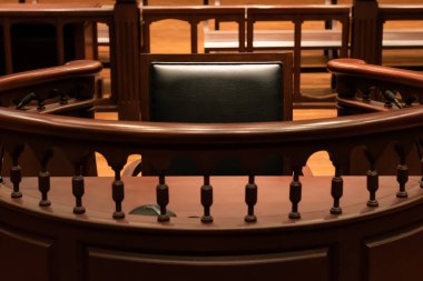 A witness stand with a black seat in the court room in front of tribunal when witness testify of evidence to judge, they will sit at here for testimony of witnesses, it is vintage or retro style clipart