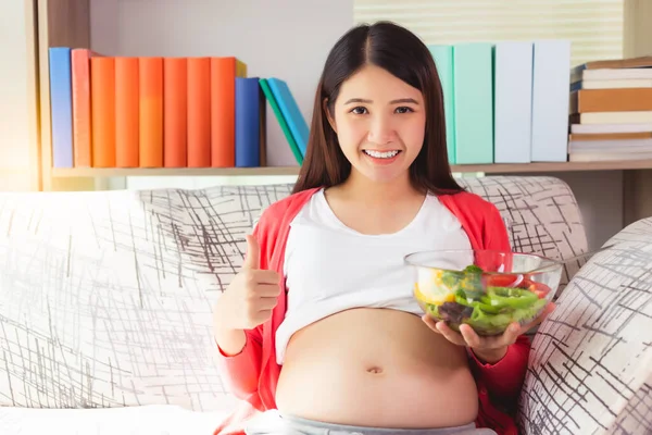 怀孕的亚洲女人拿着沙拉碗 笑容满面地放弃 蔬菜是怀孕母亲的健康食品 妈妈关心和关心她的婴儿或胎儿 母性概念 — 图库照片