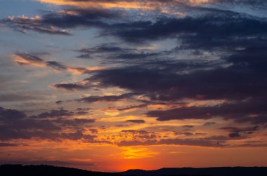 Bir alanın üzerinde dramatik bulutlar ile renkli günbatımı