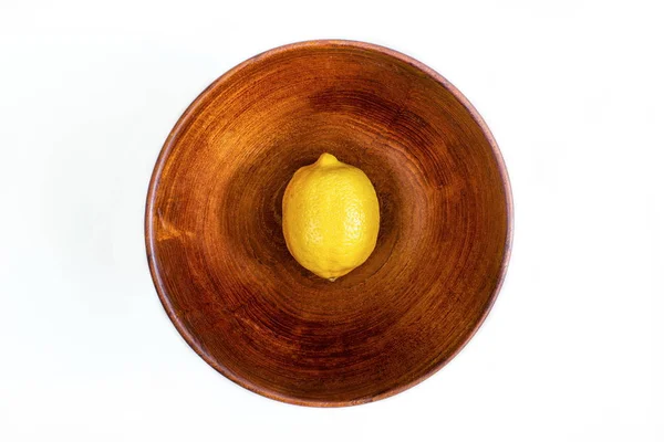 Single ripe yellow lemon inside a round wooden fruit bowl isolat — Φωτογραφία Αρχείου
