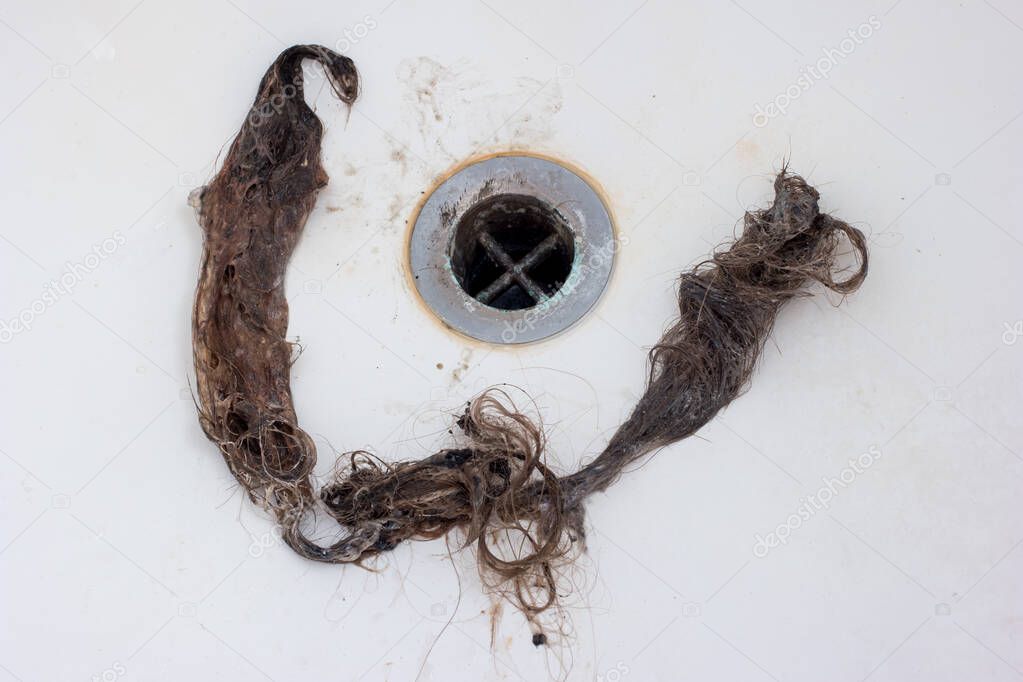 Home bath tub drain clogged by long stain of clumped hairs 2020