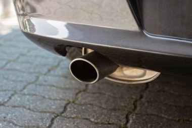 Araba motoru tek egzoz metal uçlu. Arka tamponun yanında yakın çekim..