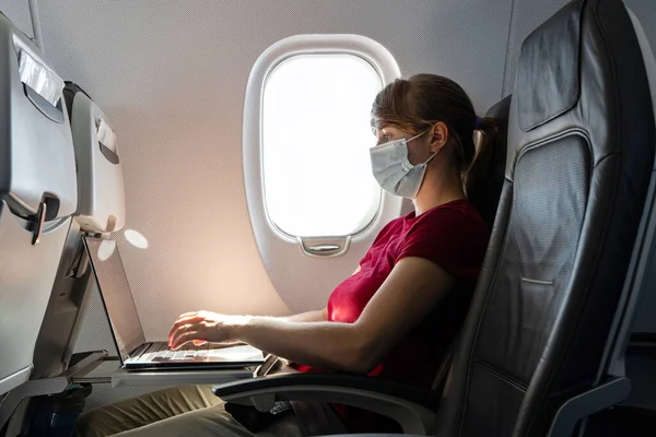 Белая Молодая Женщина Пандемической Маске Лица Работающая Ноутбуке Самолете Время — стоковое фото