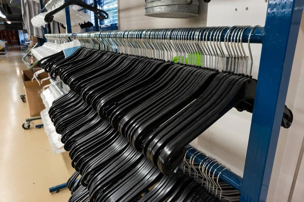 Ряд Черных Пластиковых Вешалок Пальто Висящих Металлическом Столбе Внутри Фабрики — стоковое фото