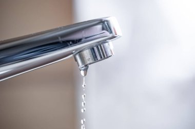 Daire banyosunun içine su damlacıkları damlatıyor. Macro, yakın çekim, alan derinliği, insan yok.