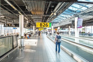 Amsterdam Schiphol Havaalanı, Hollanda, 25 Ağustos 2025. Geçitleri ve varış terminali koridorundaki insanları hareket ettiriyoruz. Geniş açı görünümü, doğal pencere ışığı