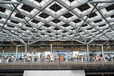 Lahey, Hollanda, 26 Ağustos 2025. Tren istasyonunun modern binasının içinde askıya alınmış tren platformu var. Geniş açı, insanlar bekliyor.