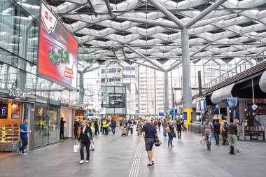 Lahey, Hollanda, 26 Ağustos 2025. Tren istasyonunun modern binasının içinde askıya alınmış tren platformu var. Geniş açı, insanlar bekliyor.