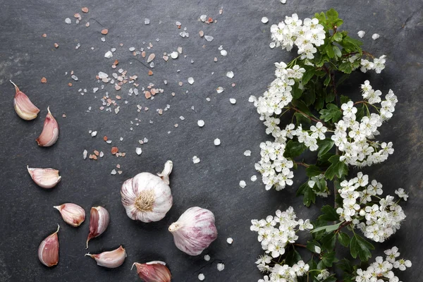 Early summer white  flower blossoms with pink garlic and Himalayan rock salt