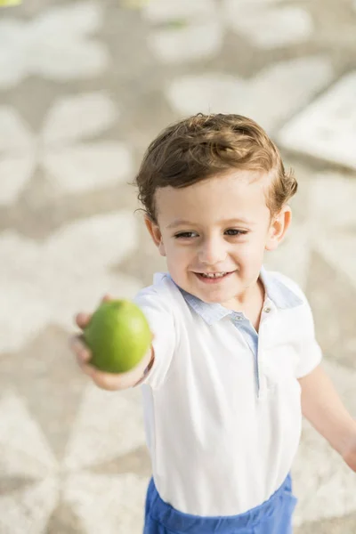 Renkli fotoğraf gülümseyen bir çocuğun elinde bir limonlu