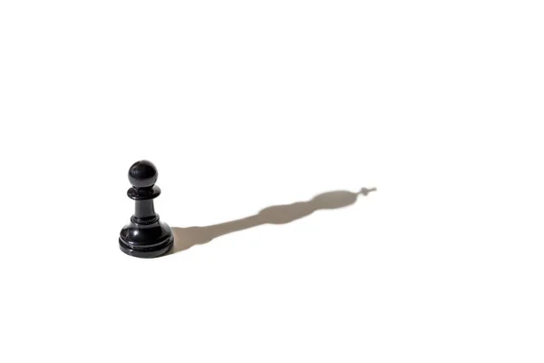 Chess pawn casting the shadow of the king. Conceptual photography that can illustrate concepts such as leadership, double personality, the inner world of the individual, among others.