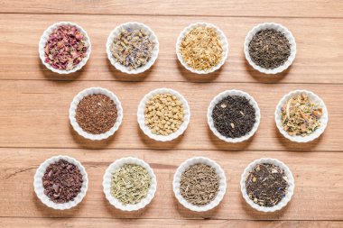 İnfüzyon, ahşap arka plan üzerinde rustik tarzı için farklı otlar ile beyaz kase.