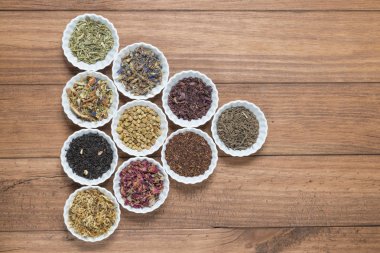 İnfüzyon, ahşap arka plan üzerinde rustik tarzı için farklı otlar ile beyaz kase.