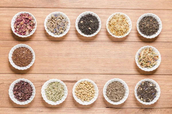 İnfüzyon, ahşap arka plan üzerinde rustik tarzı için farklı otlar ile beyaz kase.