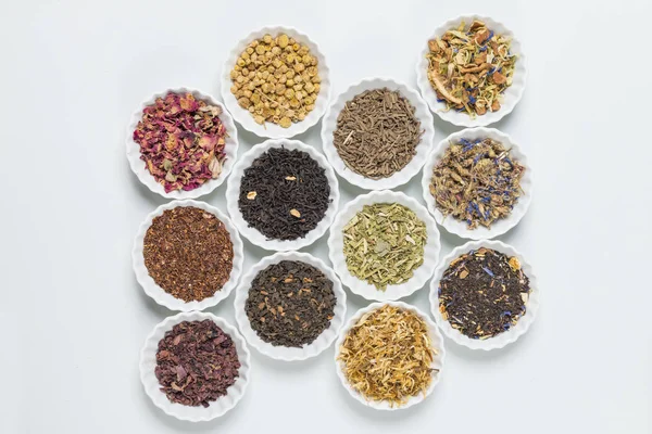 İnfüzyon, beyaz arka plan üzerinde rustik tarzı için farklı otlar ile beyaz kase.