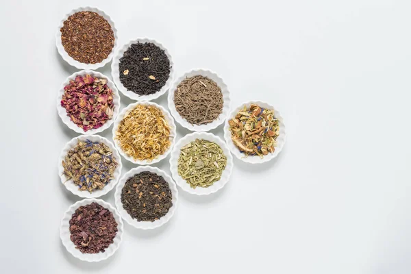 İnfüzyon, beyaz arka plan üzerinde rustik tarzı için farklı otlar ile beyaz kase.