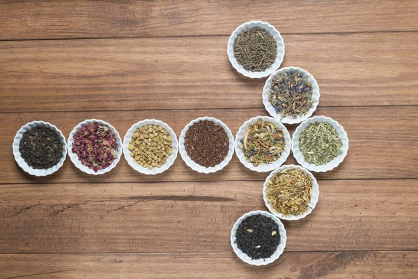 İnfüzyon, ahşap arka plan üzerinde rustik tarzı için farklı otlar ile beyaz kase.