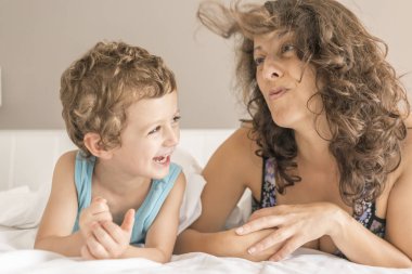 Bir kadın ve oğlu yatakta oynama ve el hareketi.