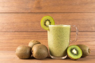 Kivi smoothie ahşap arka plan üzerinde. Sağlıklı gıda kavramı