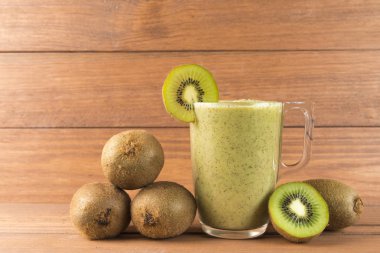 Kivi smoothie ahşap arka plan üzerinde. Sağlıklı gıda kavramı