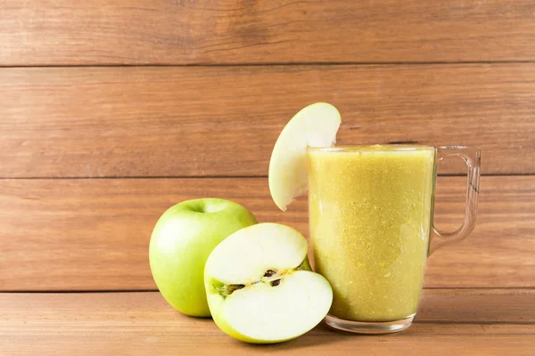 Apple smoothie on wooden background. Healthy food concept.