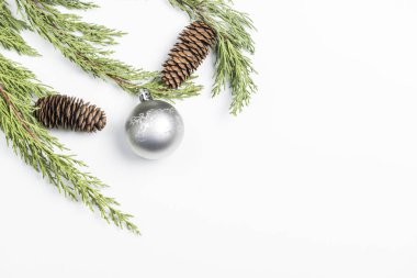 Çamın dalları, çam kozalakları ve beyaz arka plan üzerinde Noel süslemeleri ile yapılan Noel arka plan.