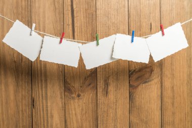 Bir ip içinde belgili tanımlık geçmiş ahşap Komiteler ile clothespins ile yılbaşı tebrik kartları ile arka plan yerleştirilen.