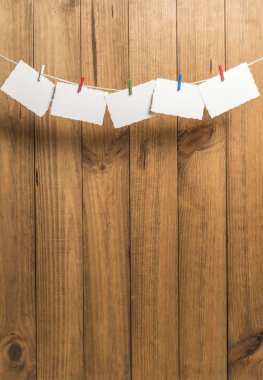 Bir ip içinde belgili tanımlık geçmiş ahşap Komiteler ile clothespins ile yılbaşı tebrik kartları ile arka plan yerleştirilen.