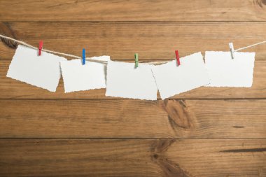 Bir ip içinde belgili tanımlık geçmiş ahşap Komiteler ile clothespins ile yılbaşı tebrik kartları ile arka plan yerleştirilen.