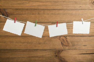 Bir ip içinde belgili tanımlık geçmiş ahşap Komiteler ile clothespins ile yılbaşı tebrik kartları ile arka plan yerleştirilen.