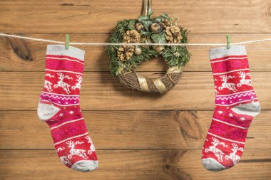 Bir ip içinde belgili tanımlık geçmiş ahşap Komiteler ile clothespins ile Noel arka plan iki kırmızı çorap ile yerleştirilen.