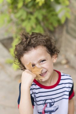 Sonbahar kavramı. Bir sonbahar ile oynayan çocuk yaprak düşer.